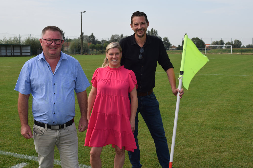 Drie leden van Team Burgemeester aan de cornervlag op het voetbalveld van SKS